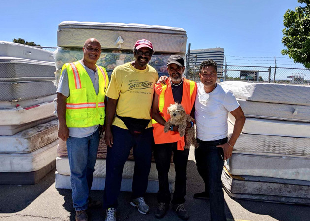 Supervisor Miley with mattresses raising awareness on illegal dumping